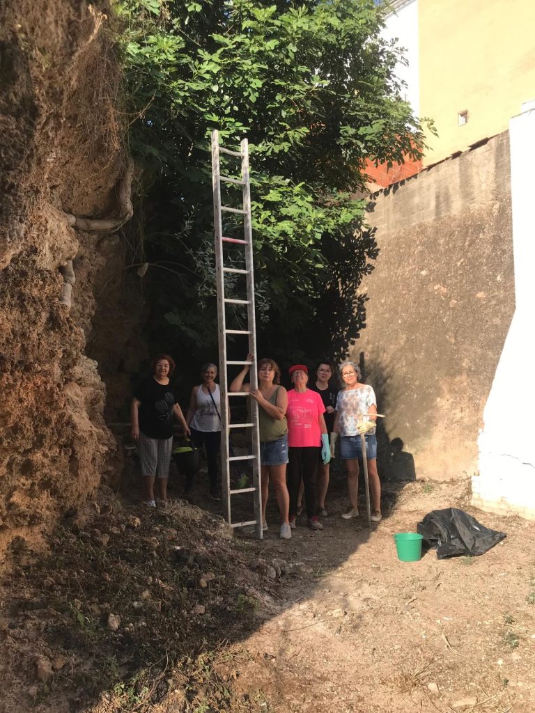 Integrantes de la asociación del Castillo de Buñol reacondicionando el terreno aledaño al local social.