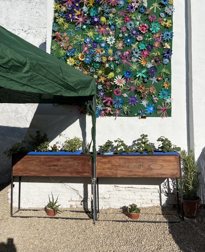 Friso con flores recicladas en el lateral del local de la asociación del Castillo de Buñol.