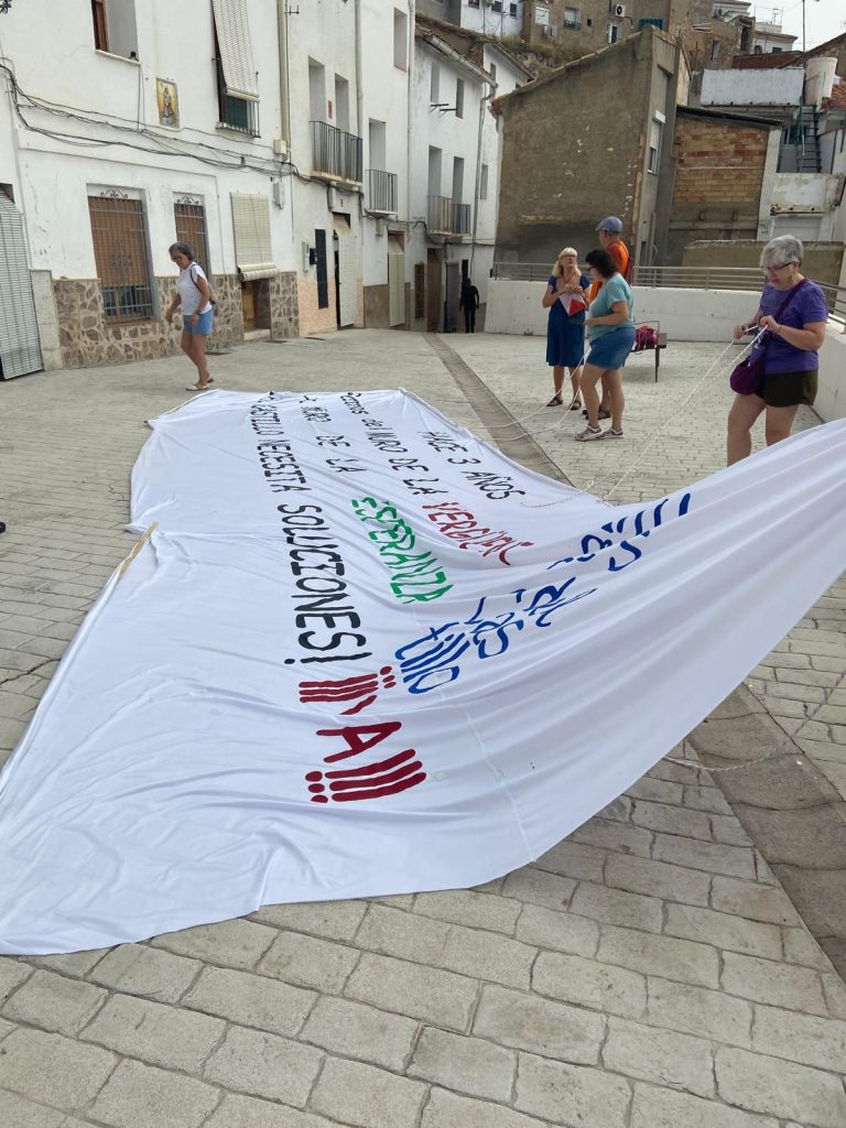 Extiendiendo la pancarta para colgarla.
