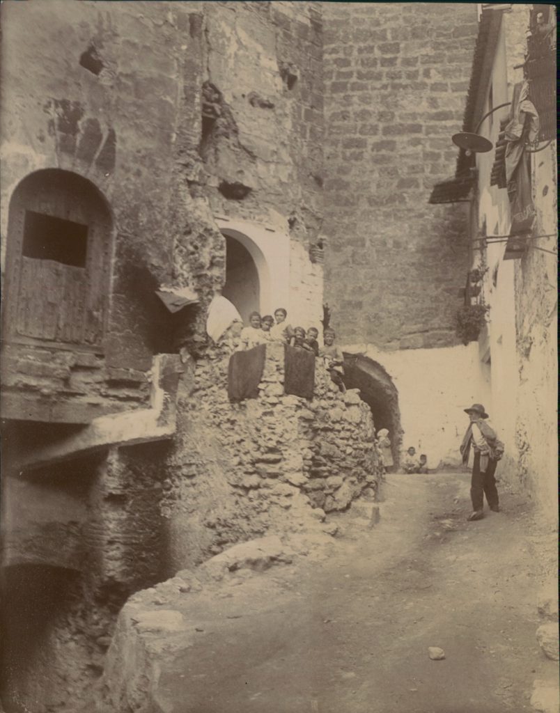 Un hombre subiendo hacia el castillo y niños mirando desde lo alto